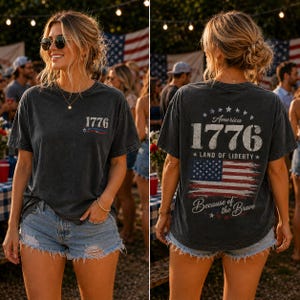 May include: Dark gray t-shirt with the number "1776" and an American flag design. The back of the shirt features the text "America 1776 Land of Liberty" and "Because of the Brave" with a distressed American flag.