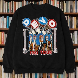 May include: Black sweatshirt featuring a graphic of the band Devo with the word "DEVO" in a circular design above the band members. The text "1981 TOUR" is printed below the band members.