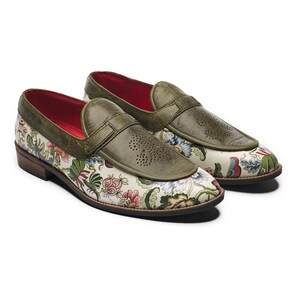 Könnte beinhalten: Ein Paar Loafer mit floralem Muster. Die Schuhe haben eine cremefarbene Basis mit einem farbenfrohen Blumendesign. Die Oberseite des Schuhs ist aus olivgrünem Leder mit einem perforierten Design. Der Innenraum ist rot.