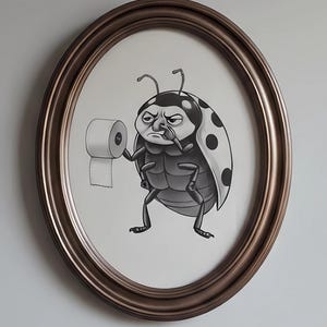 May include: A framed illustration of a grumpy ladybug holding a roll of toilet paper. The ladybug is black and white with a spotted wing design. The frame is oval and bronze-colored.