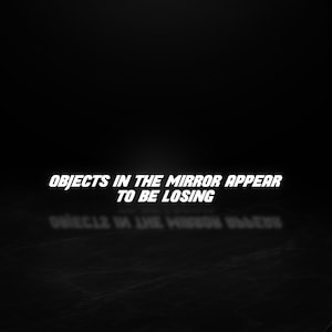 May include: Black and white image with the text "OBJECTS IN THE MIRROR APPEAR TO BE LOSING" in a bold, white font. A mirrored reflection of the text is visible below. The background is a solid black.