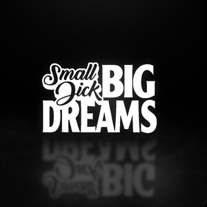 May include: A black and white graphic design with the words "Small Dick Big Dreams". The text is in a bold, sans-serif font, with "Small Dick" in a cursive font. The image has a reflective surface.