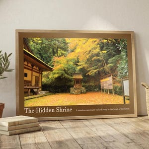May include: Framed print depicting a Japanese shrine in autumn. The image shows a traditional building, a small shrine, and vibrant trees. The text "The Hidden Shrine" is displayed at the bottom of the frame.