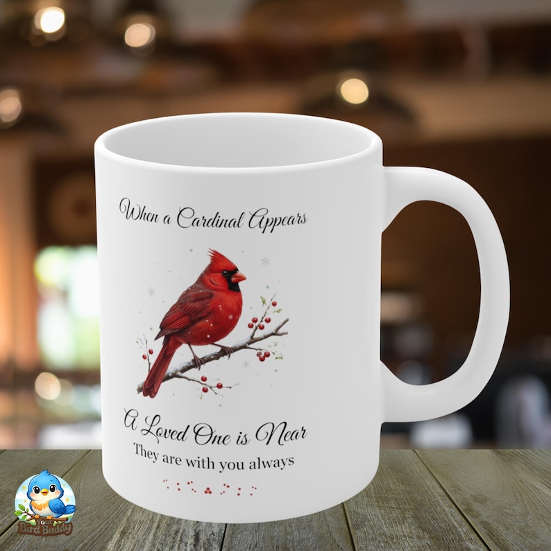 Pode incluir: Caneca de cer&acirc;mica branca com um cardeal vermelho num galho. A caneca tem o texto: "Quando um cardeal aparece, um ente querido est&aacute; perto, eles est&atilde;o sempre com voc&ecirc;."