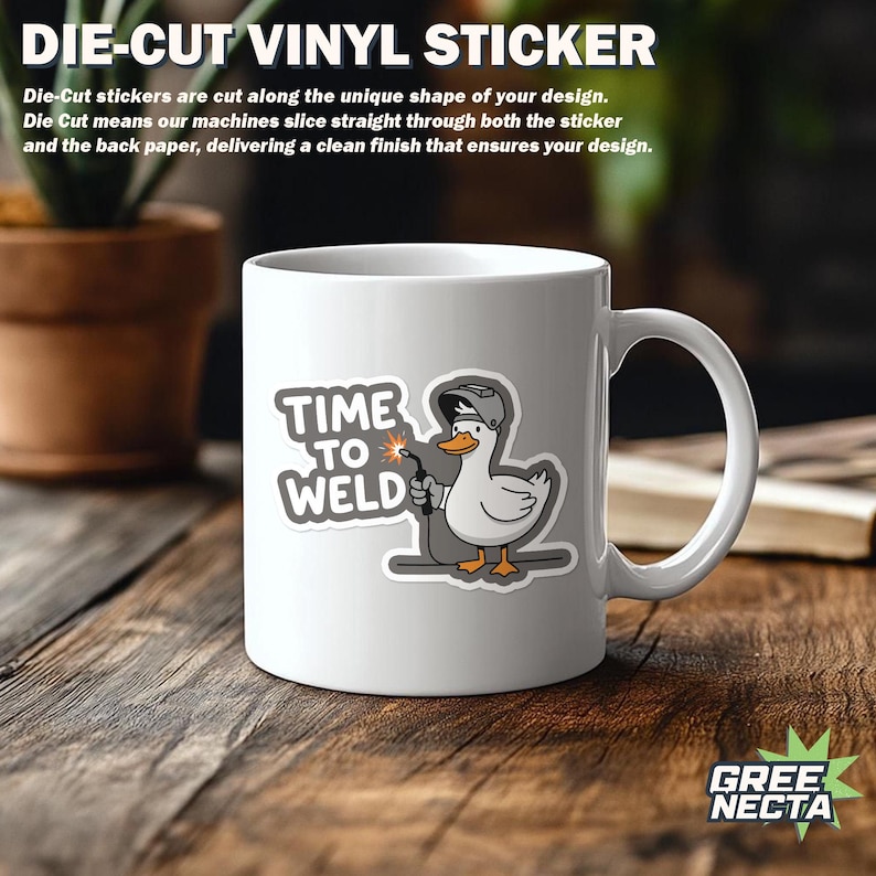 Pu&ograve; includere: Tazza in ceramica bianca con un adesivo di un'anatra saldatore dei cartoni animati con la scritta "TIME TO WELD". L'anatra indossa un casco da saldatore e tiene in mano una torcia. La tazza &egrave; su una superficie di legno.