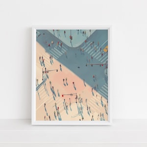 May include: An art print depicting a city intersection from above, with people crossing at zebra crossings. The artwork uses a palette of light blue, peach, and shadows, framed in white.