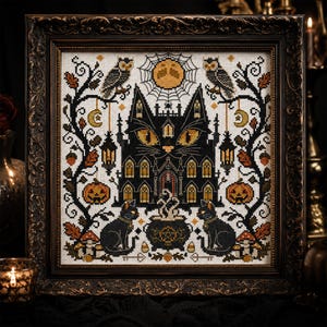 K&ouml;nnte beinhalten: Gerahmte Kreuzstichkunst mit einem schwarzen katzenf&ouml;rmigen Spukhaus mit gelben Augen. Das Design umfasst Eulen, K&uuml;rbisse, einen Kessel und einen Vollmond, alles im Halloween-Thema.