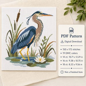 May include: A cross-stitch pattern featuring a blue heron standing in water with cattails and a white water lily. The digital download includes 19 DMC colours, a 150 x 172 stitch count, and dimensions for 14 ct, 16 ct, and 18 ct fabric in inches.