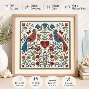 May include: Cross-stitch pattern featuring two birds, a heart, and floral elements in red, blue, and green. The design is framed in a wooden frame. The pattern includes 143 x 200 stitches, 25 DMC colors, and measures 10.2 x 14.3 inches.
