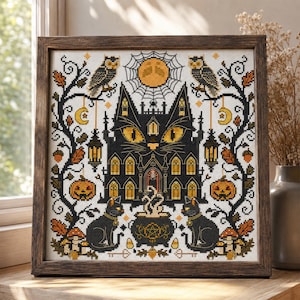 K&ouml;nnte beinhalten: Kreuzstich-Kunstwerk in einem Holzrahmen. Das Design zeigt ein schwarzes katzenf&ouml;rmiges Spukhaus mit leuchtend gelben Augen, flankiert von Eulen, K&uuml;rbissen und schwarzen Katzen. Ein Vollmond und ein Spinnennetz befinden sich im Hintergrund. Die Farbpalette umfasst Schwarz, Orange und Wei&szlig;.