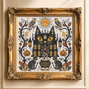 K&ouml;nnte beinhalten: Kreuzstichkunst in einem goldenen, verzierten Rahmen. Das Design zeigt ein schwarzes, katzenf&ouml;rmiges Spukhaus mit gelben Augen, flankiert von Eulen, K&uuml;rbissen und schwarzen Katzen. Ein Vollmond und ein Spinnennetz befinden sich &uuml;ber dem Haus. Das Kunstwerk hat ein Halloween-Thema.