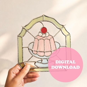 Könnte beinhalten: Buntglas-Kunstwerk, das ein rosa Dessert mit einer roten Kirsche zeigt, das auf einem Teller präsentiert wird. Das Stück ist mit einem hellgrünen Rahmen versehen. Die Worte "DIGITAL DOWNLOAD" stehen auf einem rosa Kreis.