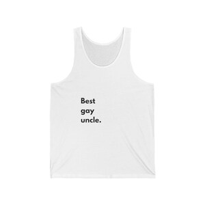 Puede incluir: Camiseta sin mangas blanca con el texto "Best gay uncle." La camiseta sin mangas está hecha de un material suave y tiene cuello redondo. Una prenda casual y cómoda.