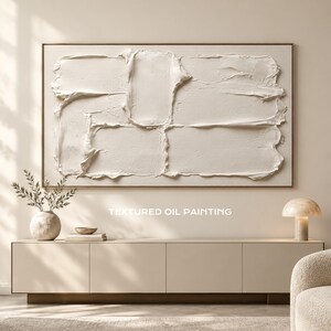 May include: A rectangular oil painting featuring thick, white impasto paint strokes applied in a layered, abstract composition. The artwork is framed in a thin, light-colored border and displays the text TEXTURED OIL PAINTING.