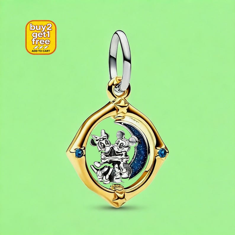 May include: A gold-toned metal pendant featuring a circular frame with star accents and two small blue stones. Inside the frame, a silver-toned figure of two cartoon mice embracing is positioned against a dark blue crescent moon with glitter details.
