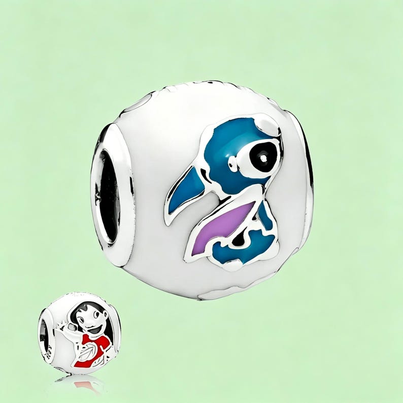 May include: A white charm bead with a blue and purple cartoon character design. The charm has a silver-colored border and a hole for threading onto a bracelet. A smaller charm with a cartoon character is also visible.
