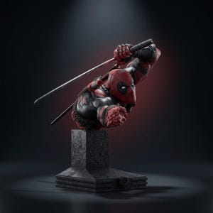 Può includere: Un busto scolpito di un personaggio che indossa una tuta rossa e nera con maschera, in una posa d'azione dinamica con un braccio teso che impugna una katana. La figura è montata su una base rettangolare nera testurizzata con incisioni.