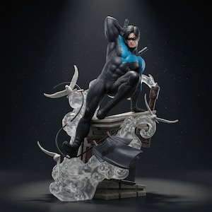 Könnte beinhalten: Eine Nightwing-Statue, die eine Figur in einem schwarzen Anzug mit blauem Brustemblem zeigt, die auf einer Ziegelstruktur hockt. Die Figur trägt zwei Escrima-Stöcke auf dem Rücken und ist von durchsichtigem Rauch, weißen Vögeln und einem T-Shirt umgeben.
