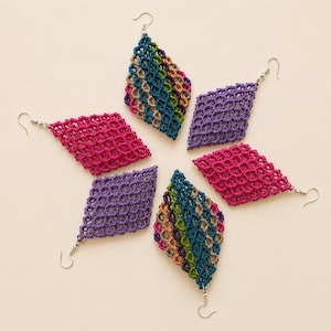 Può includere: Sei orecchini in macramè a forma di diamante con ganci in metallo color argento. Due orecchini presentano un motivo a righe diagonali multicolore, due sono magenta tinta unita e due sono viola tinta unita. Ogni pezzo ha un design a rete annodata.