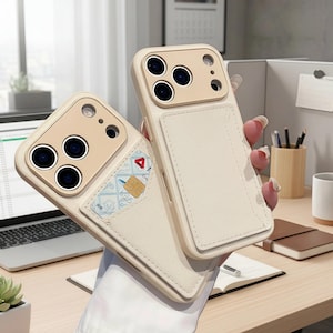 May include: Two off-white phone cases with a cardholder feature. The cases have a beige camera module and a stitched leather-like cardholder. One case displays a credit card graphic. The cases are held in front of a desk.