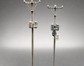 Diorama de calle con postes de servicios públicos a escala 1:64, modelo de línea eléctrica desgastada.