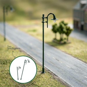 May include: Miniature dark green street lamp with a curved arm and a small light fixture. The image shows two specifications of the lamp, with the text "Two Specifications" and an arrow pointing to the lamps. The lamp is set on a miniature road.