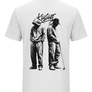 Könnte beinhalten: Ein weißes kurzärmeliges T-Shirt mit einem schwarzen Grafikdruck auf der Rückseite. Das Motiv zeigt zwei Figuren in Kapuzenpullovern und Hosen, von denen eine eine Kappe trägt und einen Golfschläger hält, mit dem Schriftzug "KILLSHOT" darüber.
