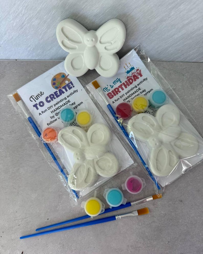 May include: White butterfly-shaped plaster craft kit with paint and brushes. The kit includes paint pots in various colors and the text "Time to Create!" and "It's my Birthday" on the packaging. A fun DIY painting activity.