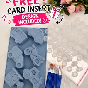 May include: A blue silicone mold featuring six vehicle shapes including a bus, car, motorcycle, and tractor. The set includes a collection of small clear plastic paint pots, a pack of thin paintbrushes with blue handles, and a card insert.
