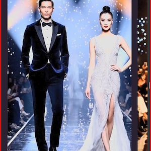 Könnte beinhalten: Ein Mann in einem marineblauen Samtanzug mit schwarzer Fliege und eine Frau in einem weißen Kleid gehen über einen Laufsteg. Das Kleid der Frau hat einen hohen Schlitz. Der Hintergrund hat einen Bokeh-Effekt.