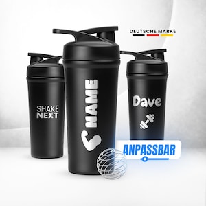 Könnte beinhalten: Schwarze Shaker-Flaschen mit Klappdeckeln. Eine Flasche trägt den Aufdruck "SHAKE NEXT", eine andere "NAME" und eine Arm-Grafik, und eine dritte "Dave" mit einer Hantel-Grafik. Eine Metall-Mischkugel liegt davor.