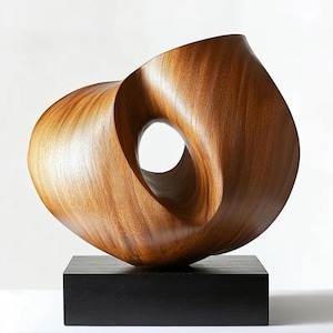 May include: A modern wooden sculpture with a flowing, organic form. The sculpture is made of light brown wood and features a central circular opening. It rests on a black square base, creating a striking contrast. The artwork is ideal for home decor.