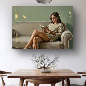 May include: An oil painting depicts a person reading on a gray sofa. The person is wearing a light green dress. The background is a muted green with gold accents. The painting hangs above a wooden table and chairs.