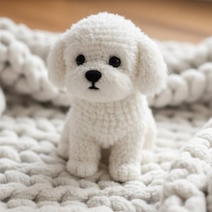 Pode incluir: Um cão de crochê branco feito à mão, com olhos e nariz pretos, está sentado em um cobertor texturizado branco sujo. O cão de pelúcia tem orelhas caídas e um corpo fofo e texturizado.