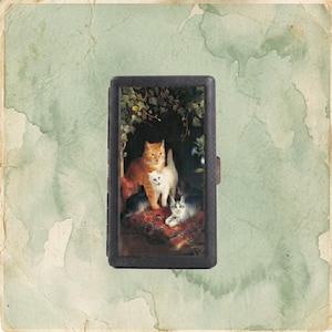 May include: A rectangular black case featuring a central illustration of four cats resting on a red patterned cushion. The cats include one orange tabby, one white cat, and two grey and white cats, all positioned beneath dark green foliage.