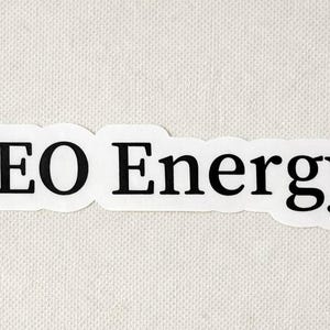 May include: A white sticker with the words "CEO Energy" in black, sans-serif font. The sticker has a rounded rectangular shape and a small black period at the end of the word "Energy".