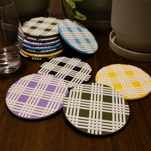 May include: A set of three ceramic mugs with a speckled, matte finish. Each mug features a different color: light blue, cream, and gray. The mugs have a simple, modern design and a capacity of approximately 12 ounces.