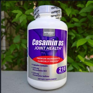May include: A white bottle of Cosamin DS Joint Health dietary supplement. The label is purple and white with the brand name and product information. The bottle contains 210 capsules and lists the ingredients.