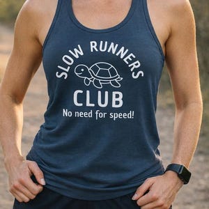 May include: A white ceramic mug with a black handle and the text "But First, Coffee" in a bold, black font. The mug is set against a blurred background, highlighting its clean design.