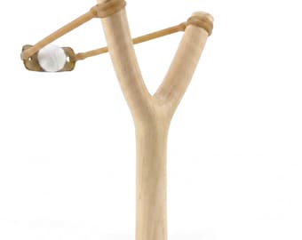 May include: A wooden slingshot with a light brown finish. The slingshot has a Y-shaped frame with a tan rubber band and a white projectile ready to launch. The design is simple and classic, suitable for outdoor play.