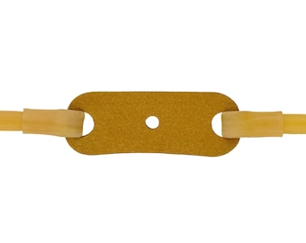May include: A brown leather slingshot pouch with two yellow rubber bands attached. The pouch has a small hole in the center.