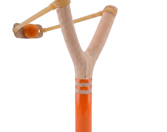 May include: A wooden slingshot with a bright orange handle and two white stripes. The slingshot has a light brown rubber band and a small orange ball. The slingshot is a classic toy.