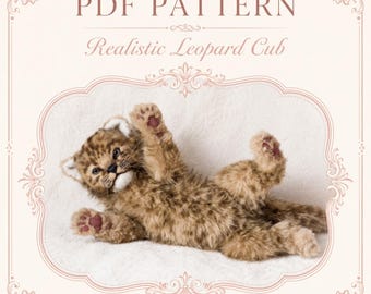 May include: A PDF pattern for a realistic leopard cub, featuring text that reads PDF PATTERN Realistic Leopard Cub. The image displays a plush, brown and tan spotted leopard cub toy lying on its back with paws raised, showing dark pink paw pads.