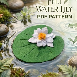 May include: A felt water lily craft project featuring a white flower with a yellow center resting on a green circular lily pad. The text "Felt Water Lily PDF Pattern" is printed in dark green letters above the craft item.