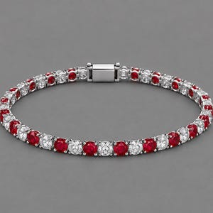 May include: A tennis bracelet featuring a repeating pattern of round-cut red rubies and clear white diamonds set in a polished silver-toned metal band. The bracelet includes a secure rectangular box clasp closure at the top centre.