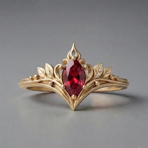 Könnte beinhalten: Ein goldener Ring mit einem zentralen, marquise-geschliffenen roten Edelstein. Die Ringschiene ist mit filigranen Metallarbeiten verziert, die an stilisierte Blätter und Ranken erinnern, welche vom Mittelstein ausgehend eine spitze Form bilden.