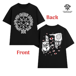 May include: Black t-shirt featuring a white pentagram design with text on the front. The back of the shirt displays a graphic of hands, eyes, and a circular design. The shirt is a short-sleeved crew neck.