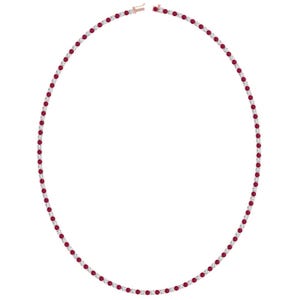 May include: A delicate necklace featuring a continuous line of alternating red gemstones and clear, round-cut stones. The necklace has a rose gold clasp and setting, creating a classic and elegant design. The gemstones are evenly spaced.