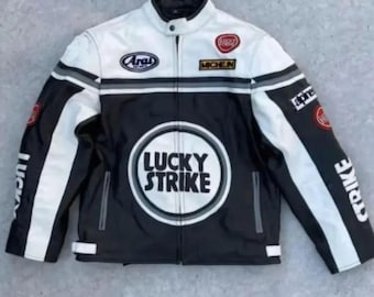 May include: Black, white, and gray motorcycle jacket with a stand-up collar. The jacket features the "Lucky Strike" logo on the front, along with other brand patches. The sleeves have white stripes and the word "STRIKE" printed on the right sleeve.