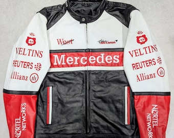 May include: A black, white, and red leather jacket with the Mercedes logo across the chest. The jacket features sponsor logos and text, including "West," "VELTINS," and "REUTERS." The jacket has a stand-up collar and a full-length zipper.